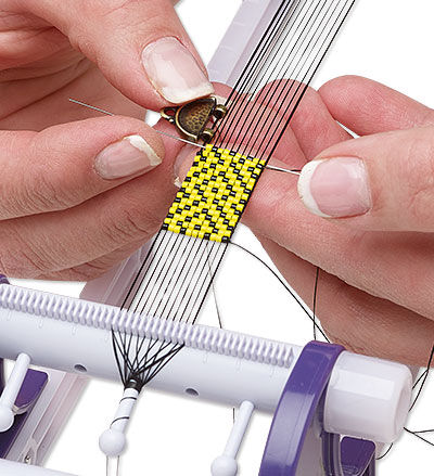Hands beading on a beading loom